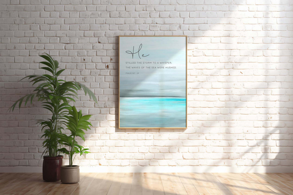 Psalm 107:29 - He stilled the storm Christian Bible verse wall art with tranquil turquoise sea design, inspirational scripture decor.