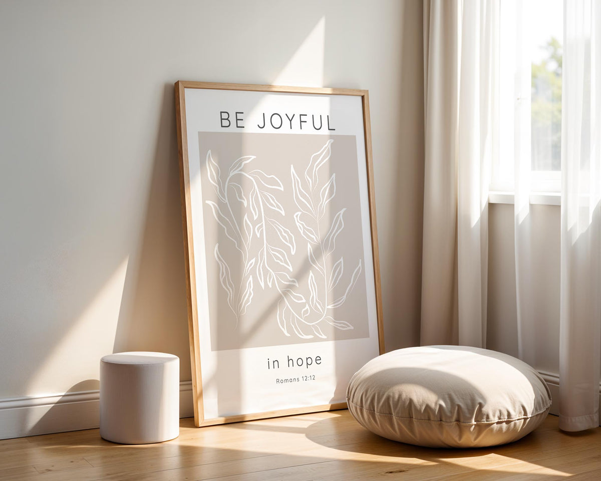 Romans 12:12 – Be joyful in hope Christian wall art with neutral beige tones and modern botanical leaf design.