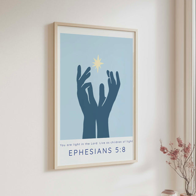 Ephesians 5:8 - Christian wall art print featuring hands reaching towards radiant light with Bible verse You are light in the Lord on soft blue background.